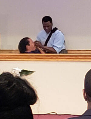Willie Williams Jr. baptizes Heidi Paul, the coach’s wife, at the North Colony Church of Christ in 2019.