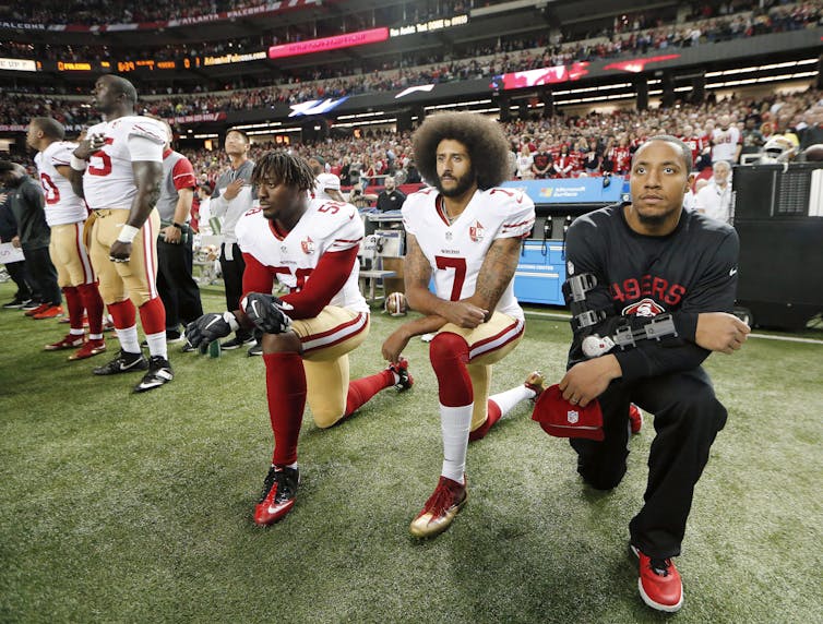 Former San Francisco 49ers quarterback Colin Kaepernick kneels during the national anthem.