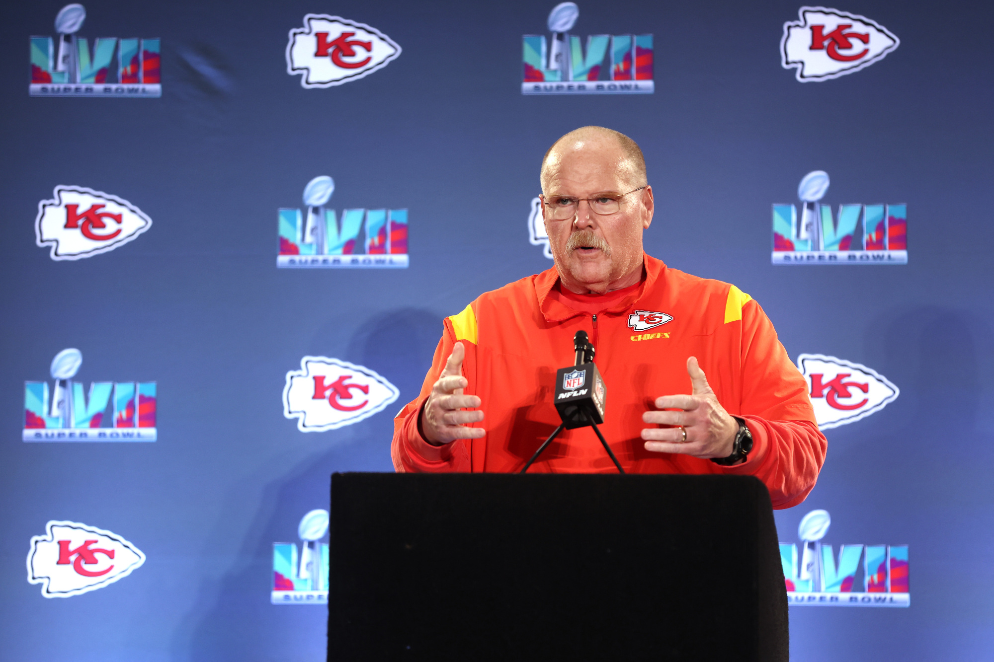 A man stands at a podium speaking to reporters.