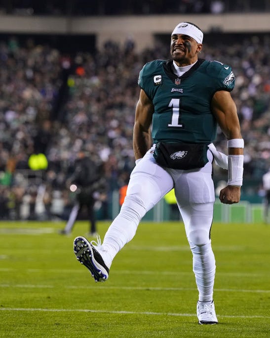 jalen hurts making a kicking motion in celebration after a football win