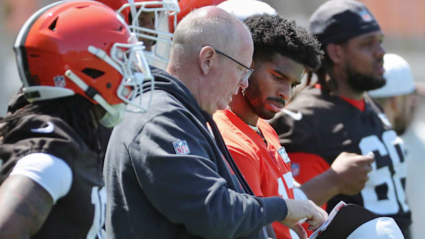 Shedeur Sanders going over the playbook on the sidelines.