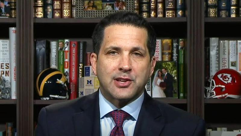 Adam Schefter with a bookshelf behind him on TV
