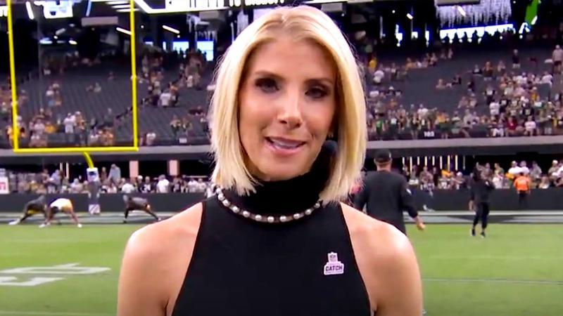 Michelle Beisner-Buck in a black dress on the football field looking at a camera