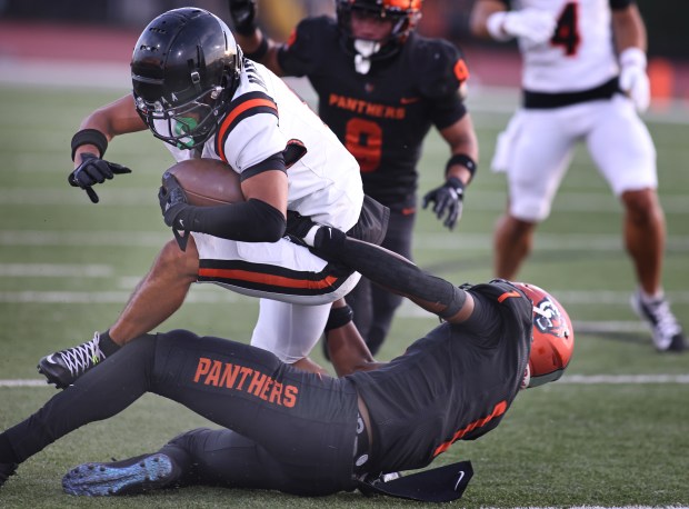 Huntington Beach's Nicolas Navarrete is tackled by Orange's (1) Hayaat Asiedu. The game was held at El Modena High School in the city of Orange on Thursday, Aug. 21, 2025.(Photos by Karen Tapia, Contributing Photographer)