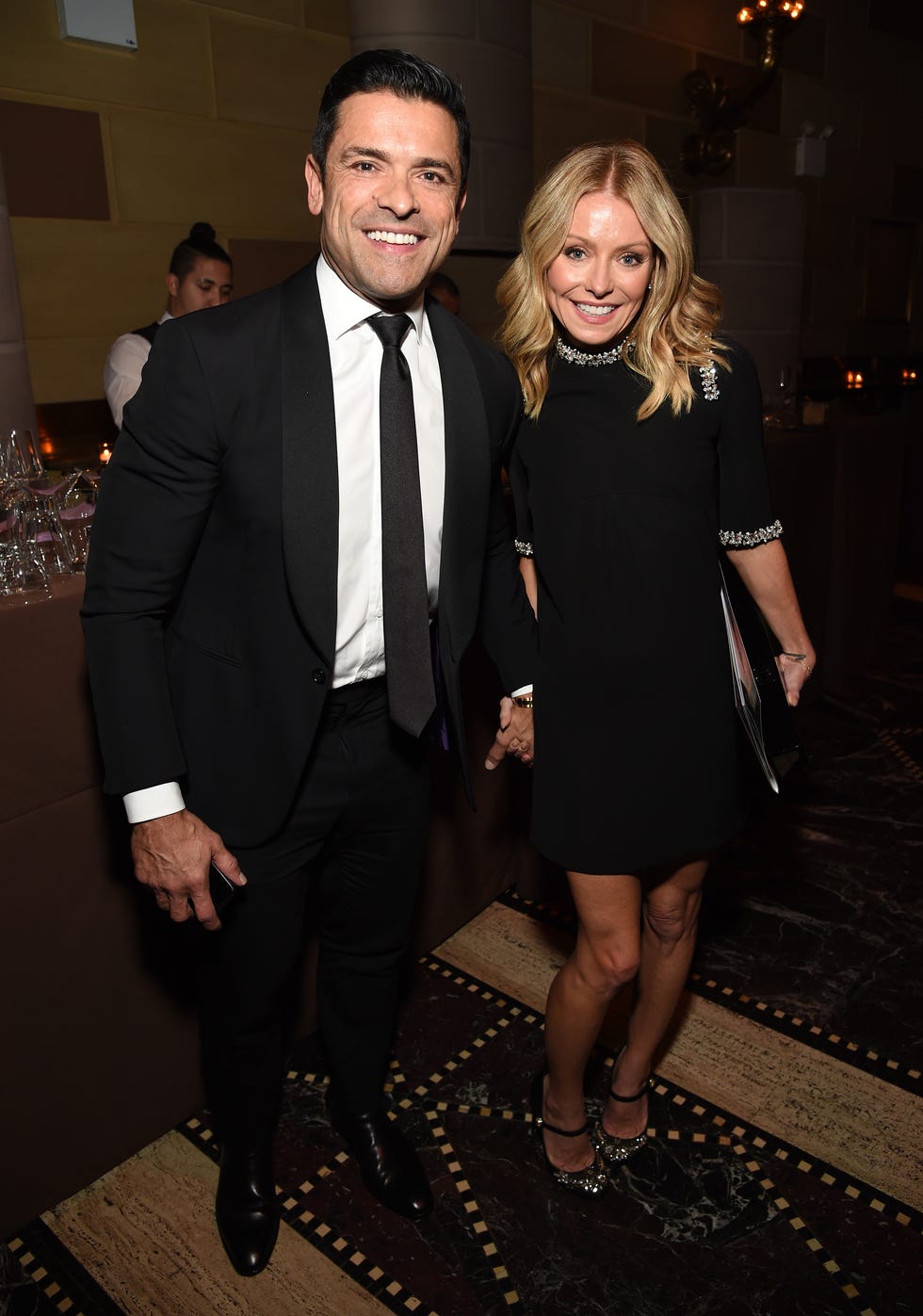 mark consuelos and kelly ripa holding hands while attending event