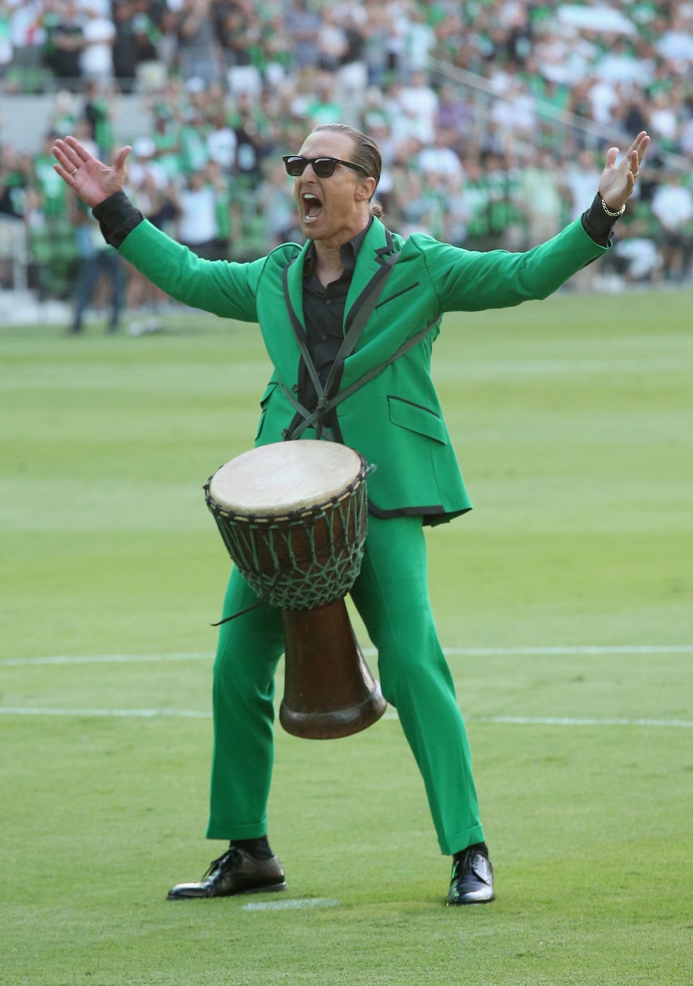 matthew mcconaughey screaming at the crowd while banging on a drum