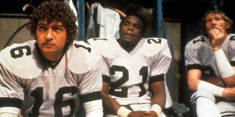 Three football players gather in the locker room