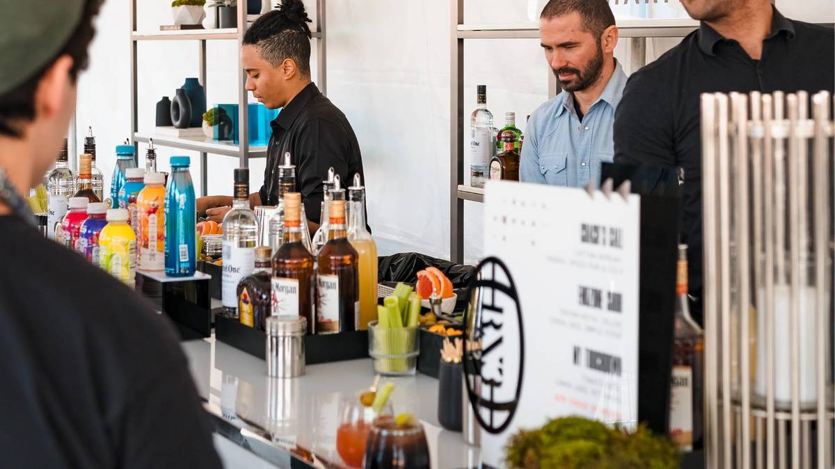 Guests grabbing drinks at the bar at the RX3 Charity Flag Football Tournament