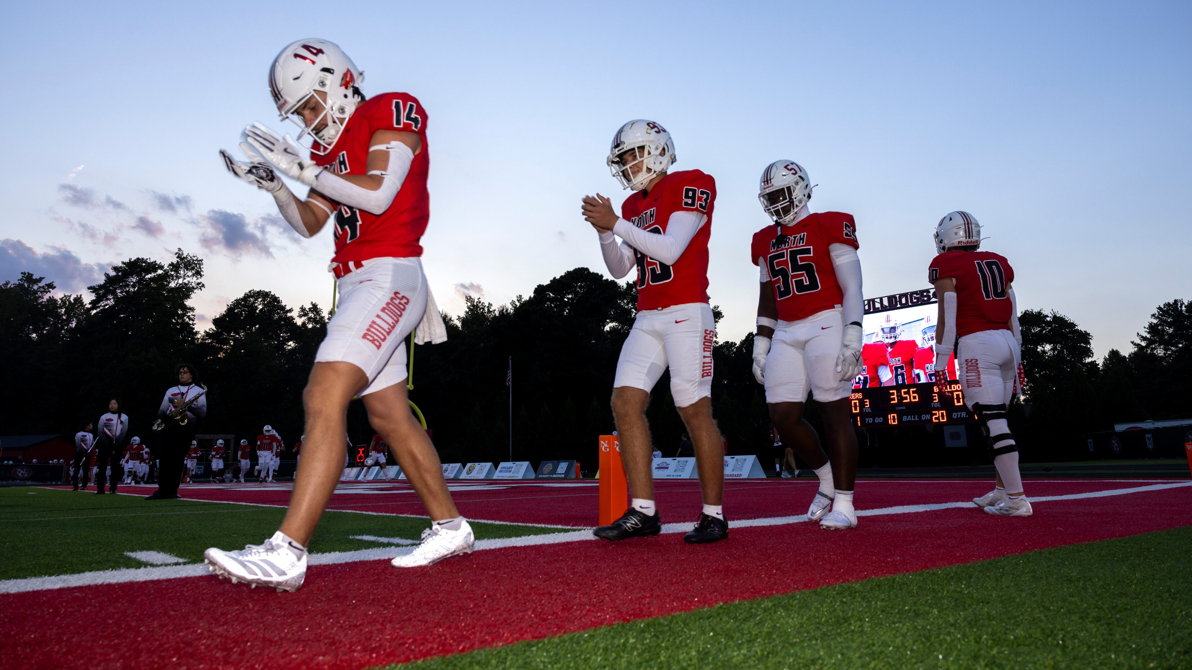 North Gwinnett captains led by Walker Buice (left) walk toward midfield for the coin toss against Colquitt County at Tom Robinson Field in Suwanee on Friday, Aug. 29, 2025. North Gwinnett won 21-7 and moved up to No. 7 in Class 6A, while Colquitt County fell to 10th in the rankings. (Jason Getz/AJC)