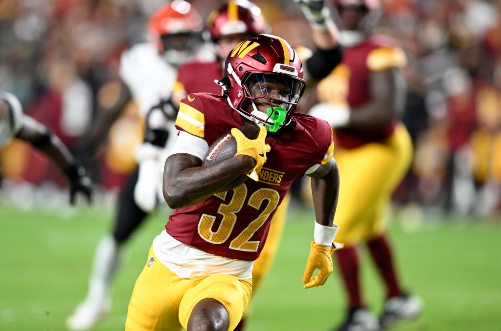 Washington Commanders player #32 running with the football.