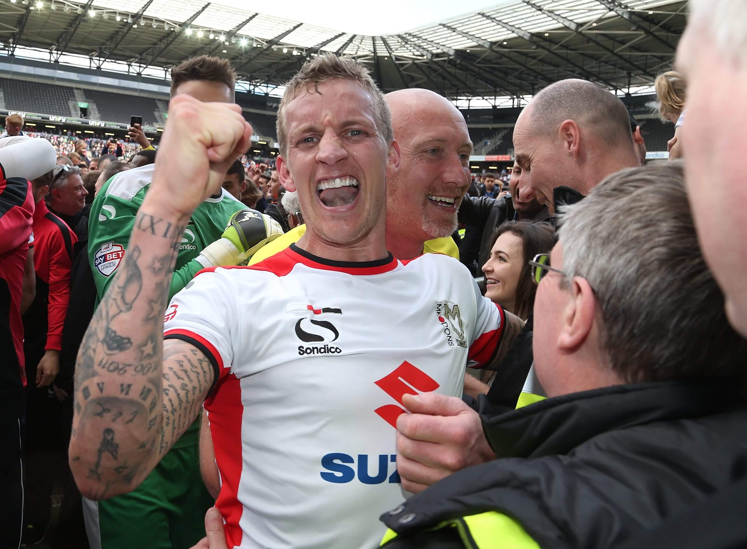 Carl Baker pumps his fist as he celebrates MK Dons' promotion from League One in 2015