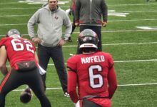 Archival full-frame photograph of Baker Mayfield and Graham Barton warming up before a 2025 Buccaneers game