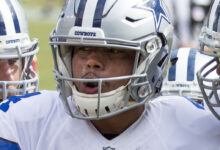 Archival full-frame photograph of Dallas Cowboys quarterback Dak Prescott in a team huddle during a 2016 game