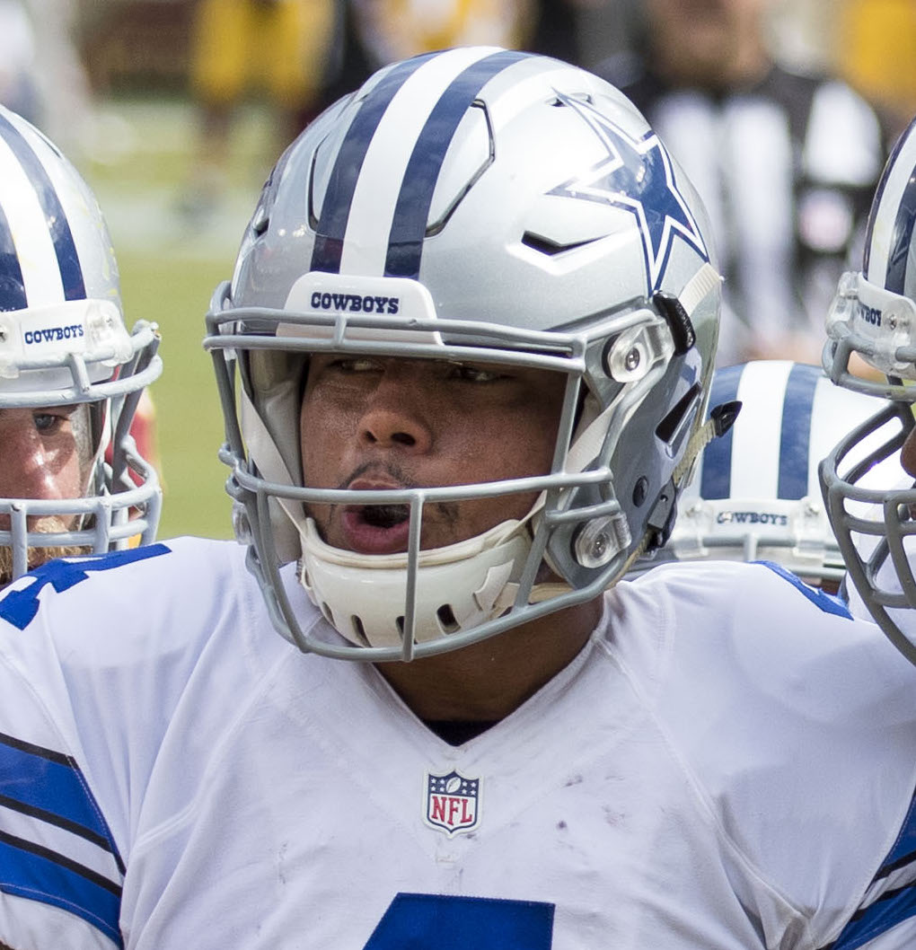 Archival full-frame photograph of Dallas Cowboys quarterback Dak Prescott in a team huddle during a 2016 game