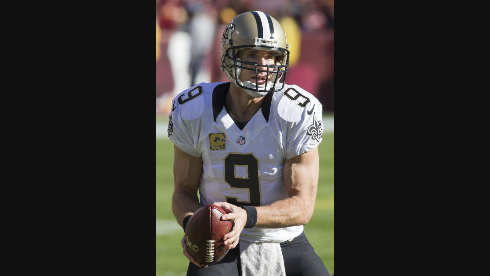 Archival photograph of Drew Brees holding a football during a 2015 New Orleans Saints game